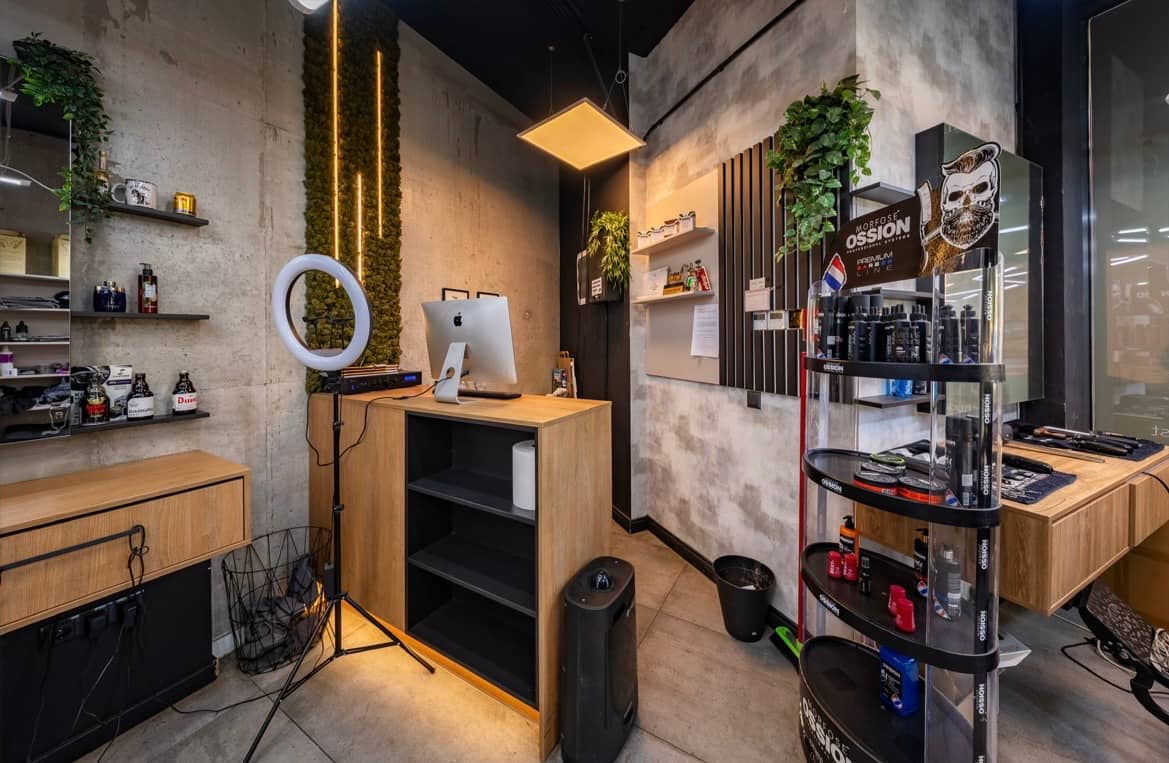 The reception desk and the shelf of grooming products against the concrete wall