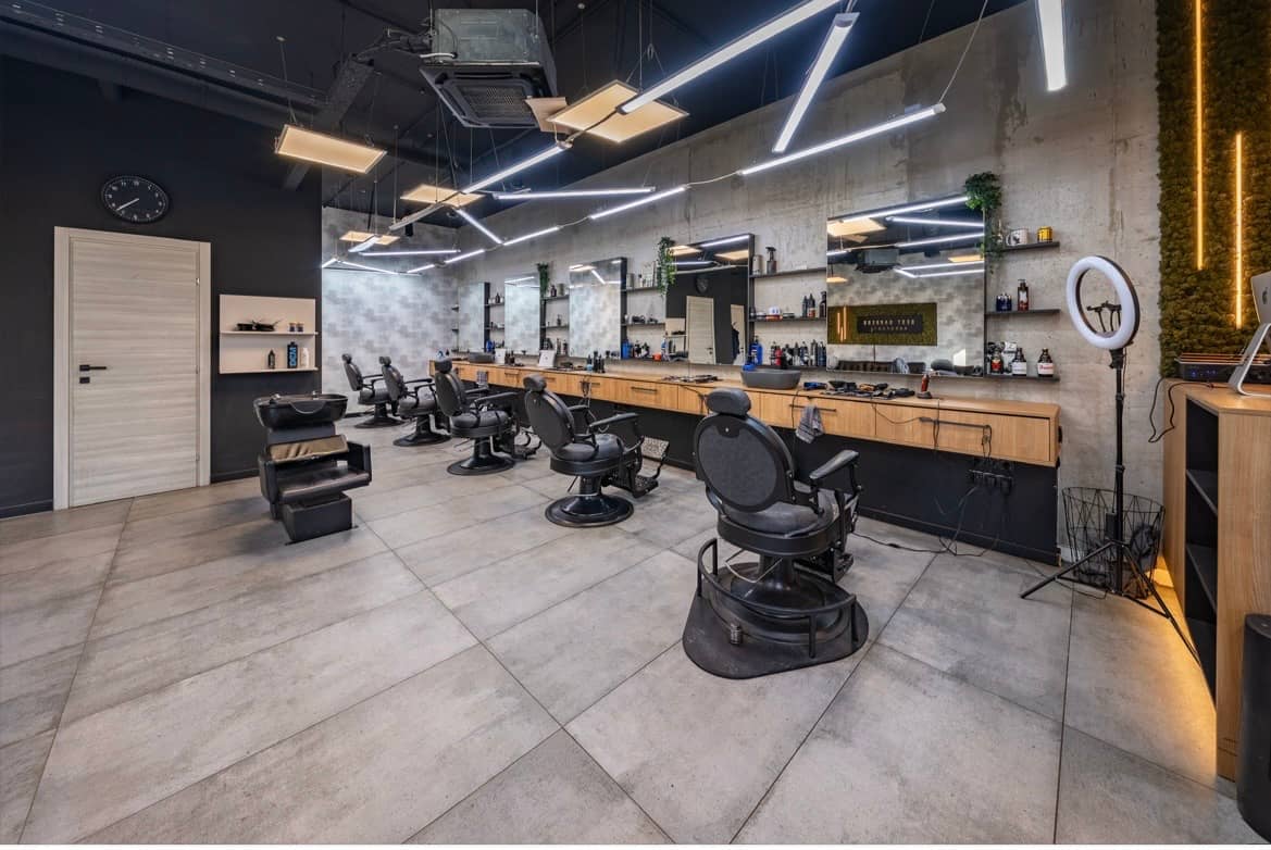The shop from the entrance: a row of barber chairs, a wash unit and mirrors