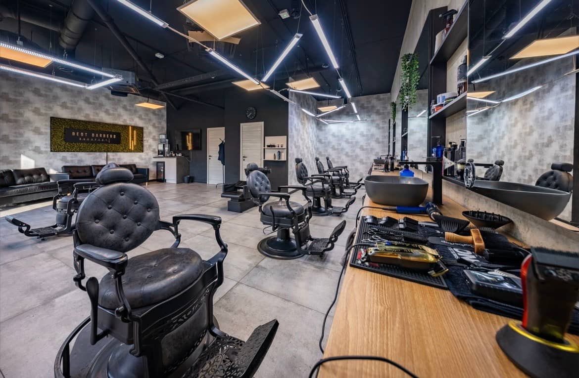 Inside Best Barbers Budapest: six barber chairs, an oak counter and concrete walls
